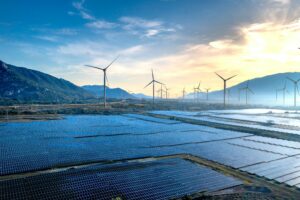Stunning landscape featuring solar panels and wind turbines at sunrise, symbolizing sustainable energy.
